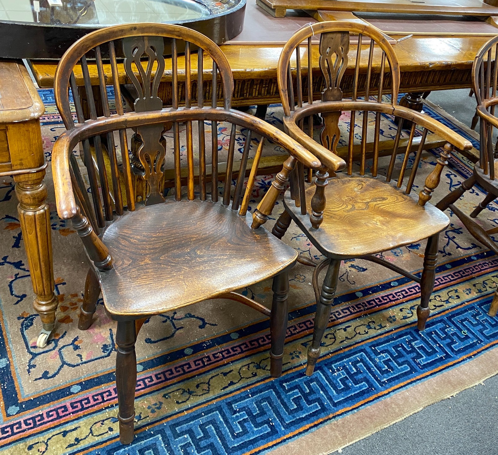 A near pair of mid 19th century yew and elm Windsor elbow chairs, with crinoline stretchers, larger width 62cm, depth 40cm, height 90cm